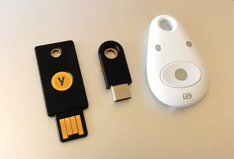 Two USB hardware authentication keys, a YubiKey 4 and a Feitian MultiPass FIDO key