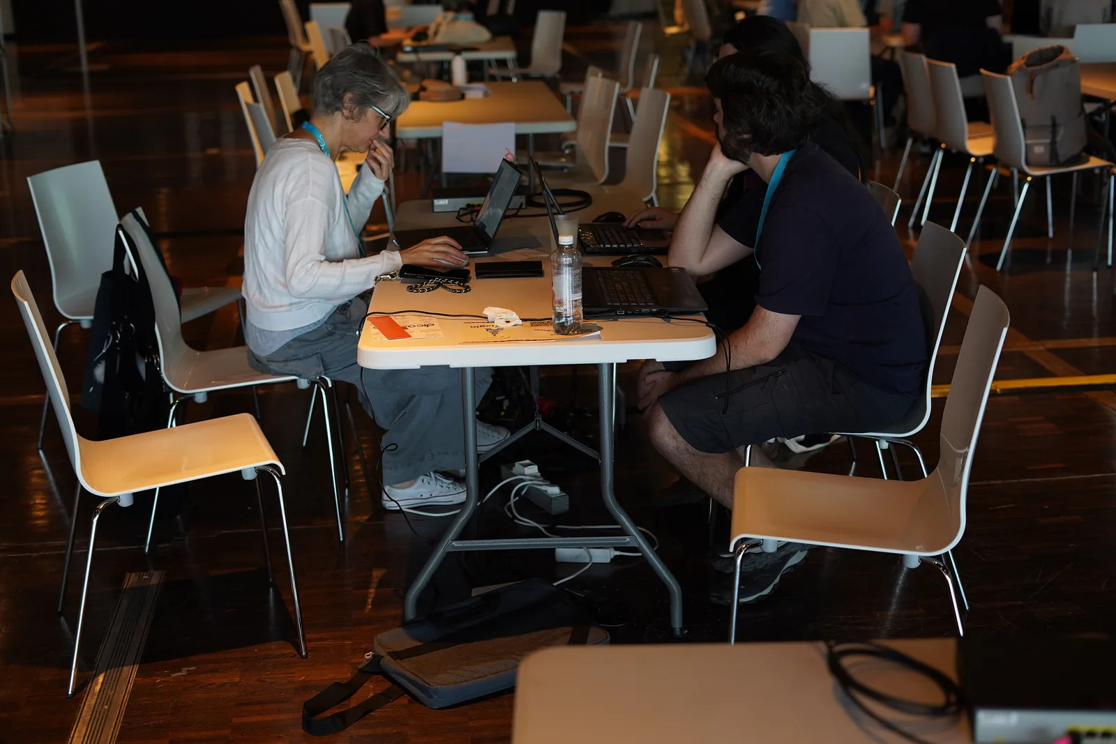Technical volunteers collaborating on laptops in a shared workspace