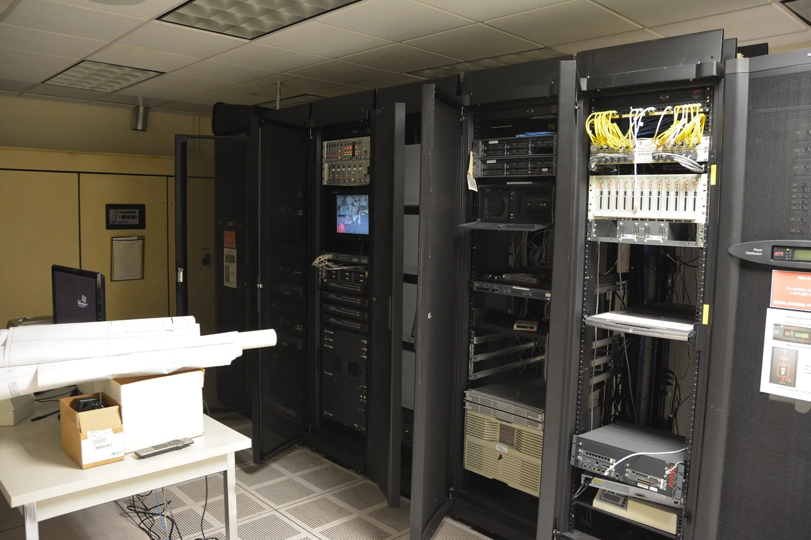 Server room with rack cabinets holding servers, network equipment and a small monitor