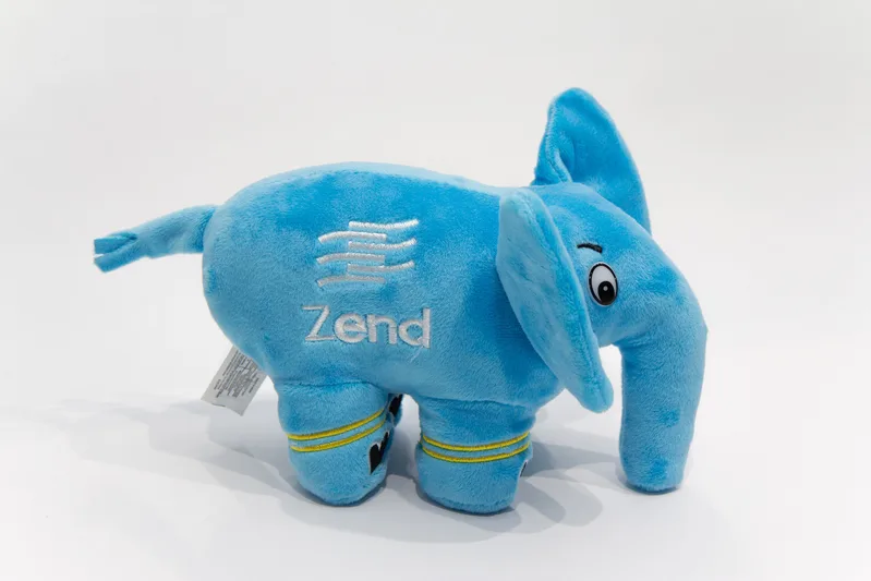 Blue plush elePHPant toy, the PHP mascot, standing on a light grey background