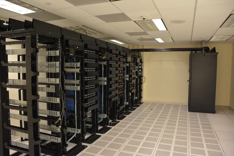 Aisle of server racks with status lights in a data centre hosting web applications