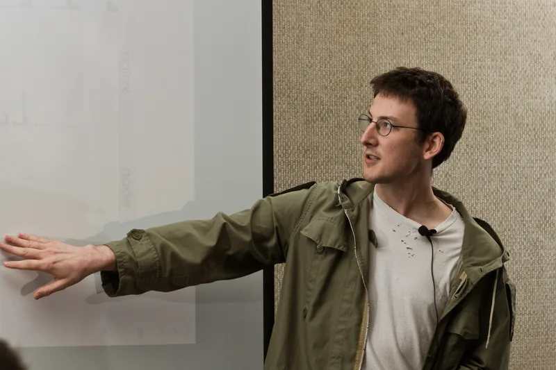 Ryan Dahl, the creator of Node.js, pointing at a projected slide during a JSConf talk
