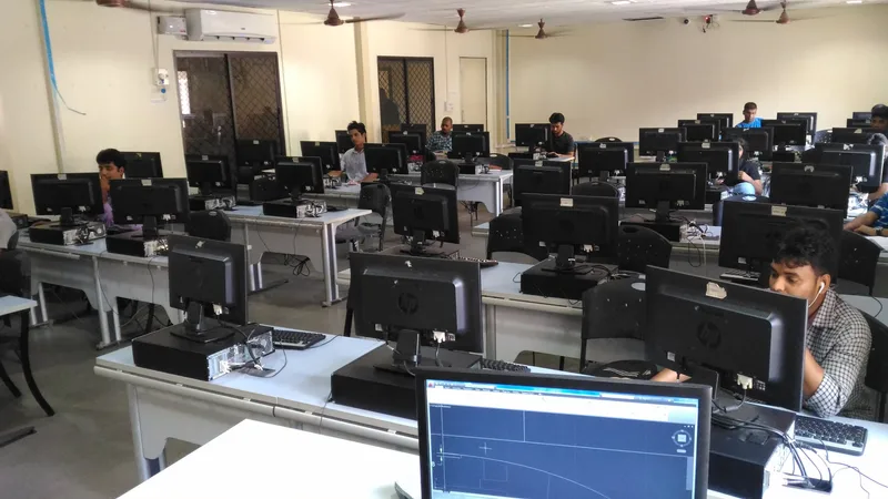 A large university computer lab with rows of desktop computers and a few students at work