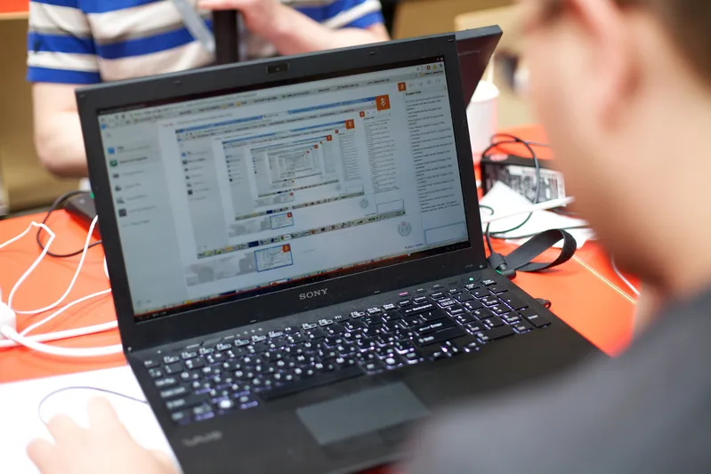 Developers working on laptops around tables at a software hackathon in Amsterdam