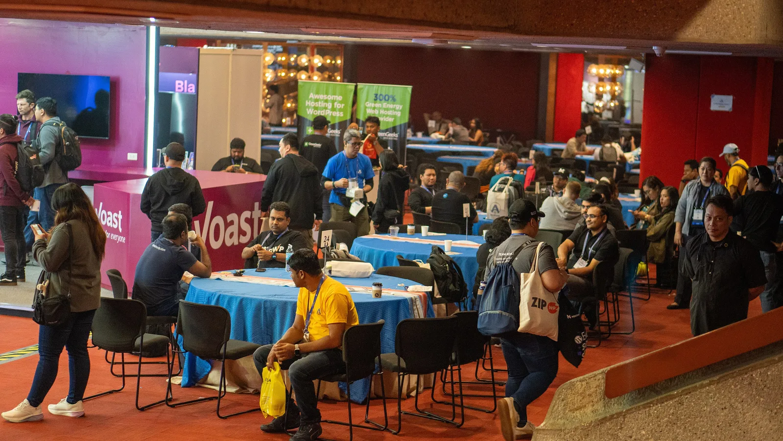 Attendees talking at round discussion tables in the reception hall at WordCamp Asia 2025
