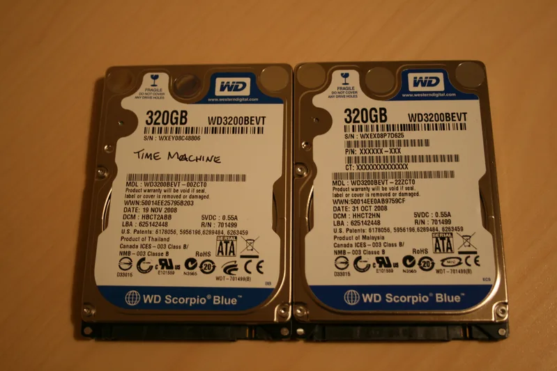 Two 2.5-inch laptop hard drives lying side by side on a table