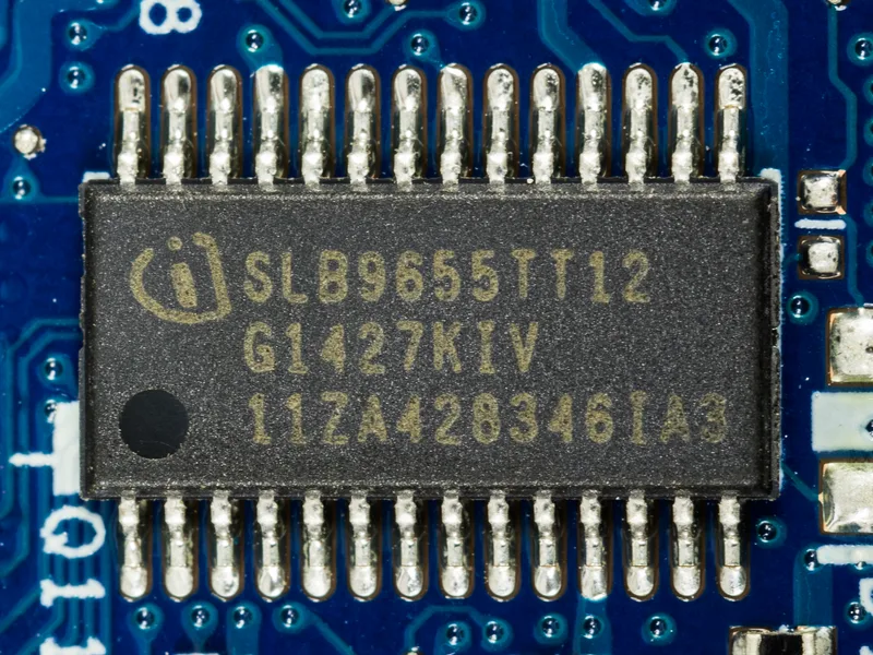 Close-up of an Infineon SLB9655 Trusted Platform Module chip soldered to a blue circuit board