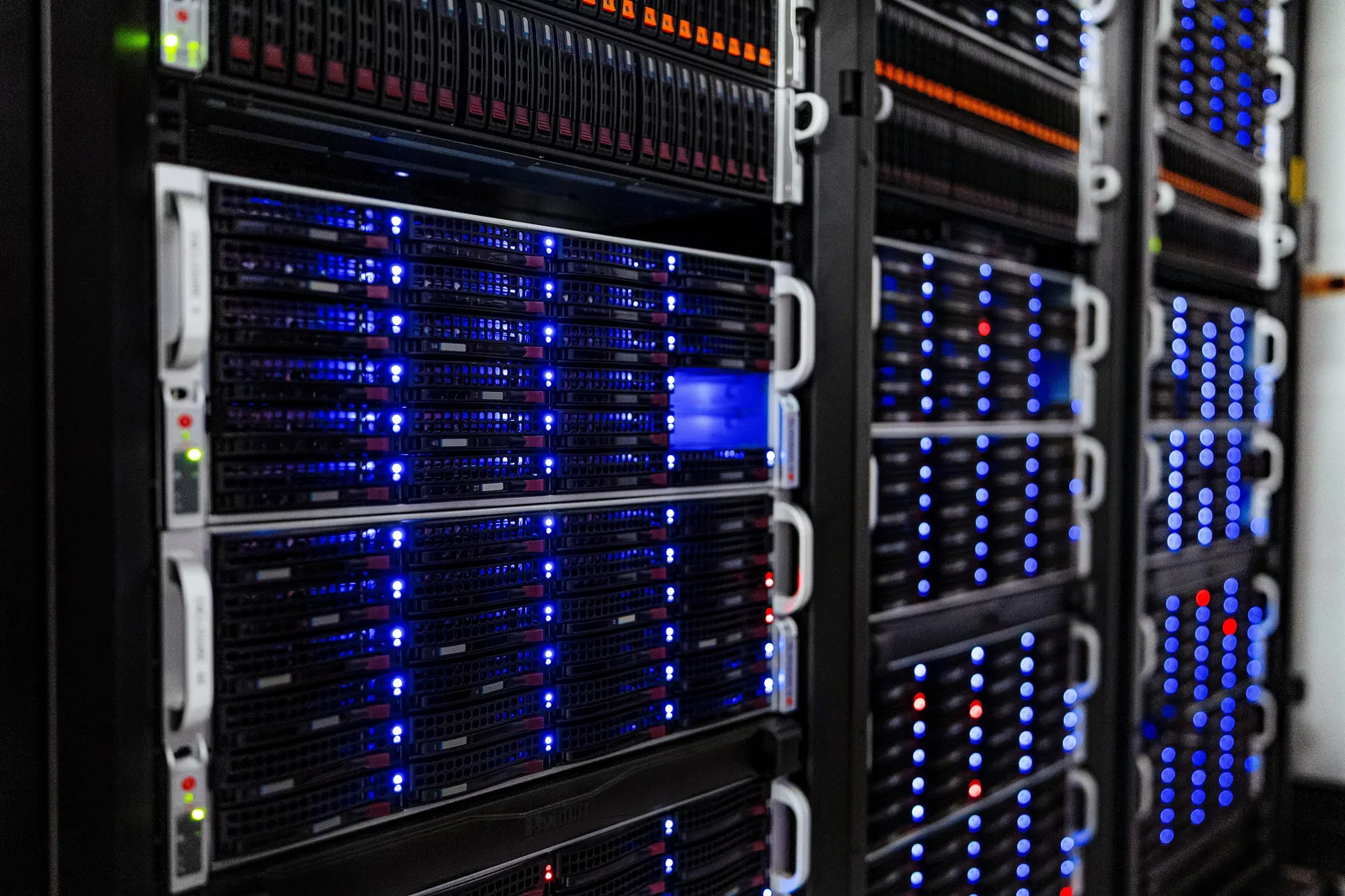 Rows of rack-mounted servers with blue status lights in a server room