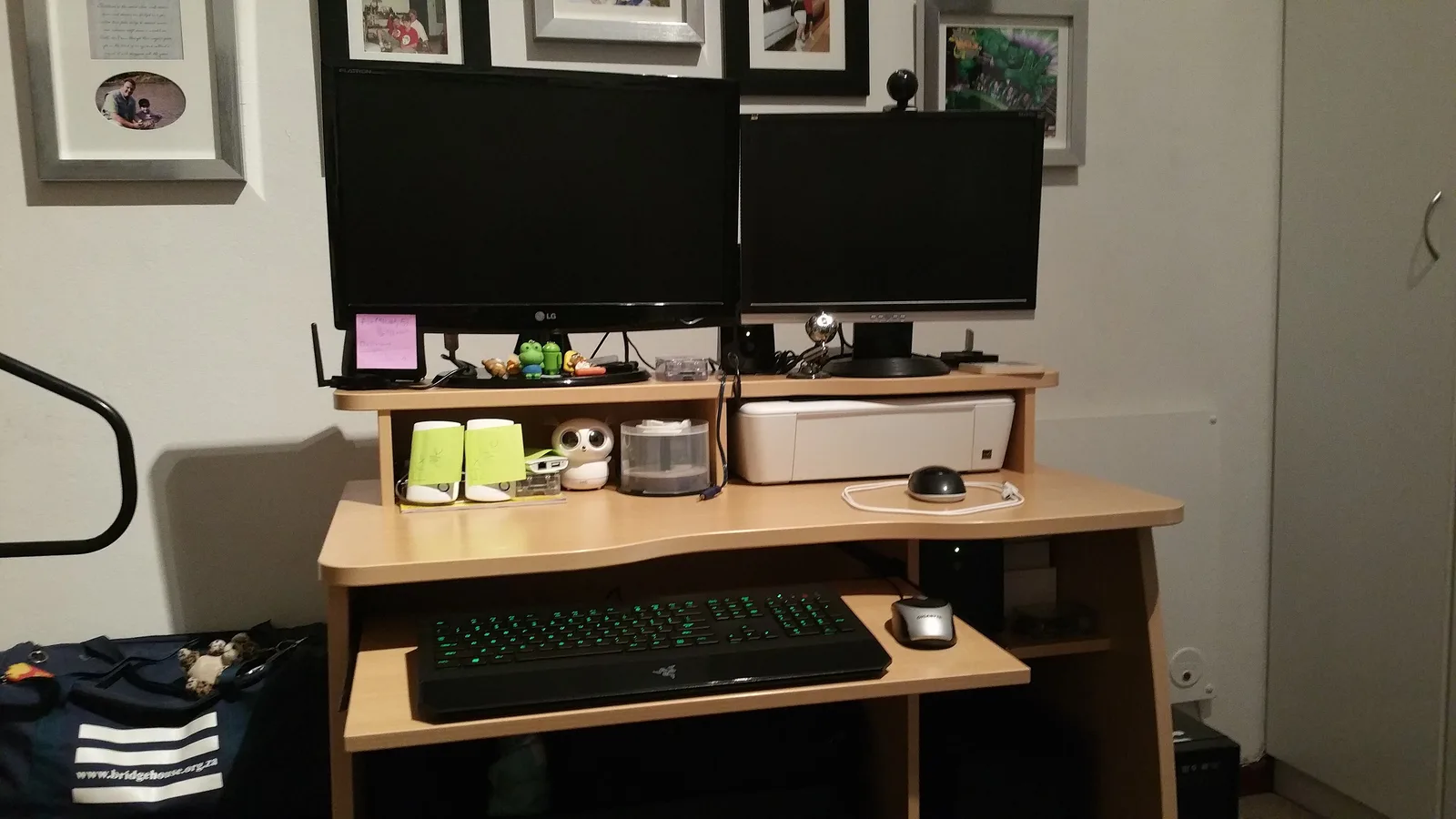 Home programming desk with two monitors, a backlit keyboard, a mouse and a small printer