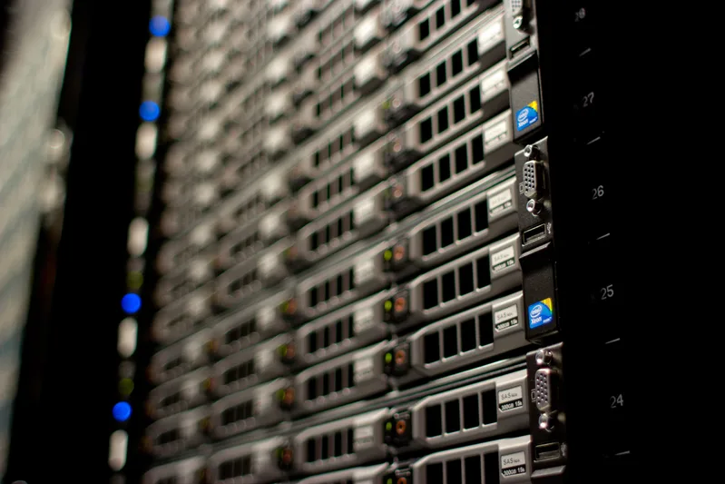 Close-up of a rack of 1U servers with drive bays and blue status lights in a dark data centre
