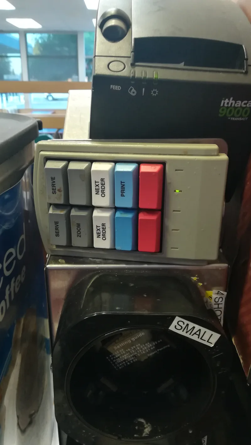 Kitchen order keypad with Serve, Zoom, Next Order and Print buttons beneath a receipt printer