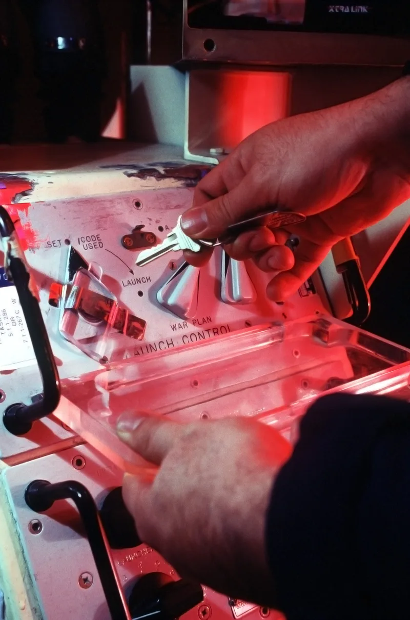A hand inserts a launch key into a Peacekeeper missile launch control panel during a 1996 simulation at F. E. Warren Air Force Base, Wyoming