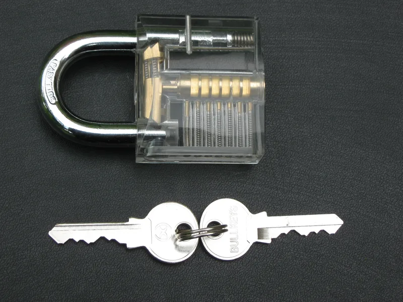 Transparent padlock with two keys, showing the lock mechanism.